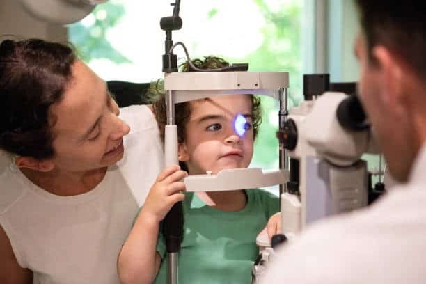 Child undergoing eye exam with slit lamp